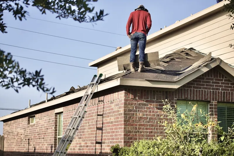 Professional roofer working on a residential roof in Kennett